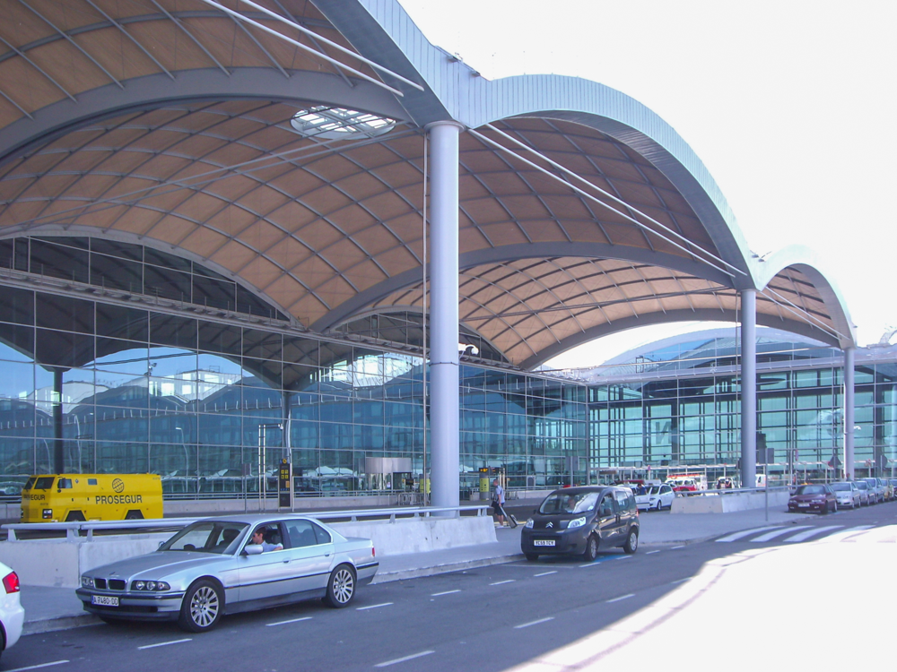 Alicante Airport terminal building with parked cars in front