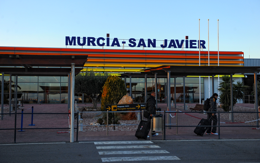 Exterior of Murcia Airport terminal with signage and travelers